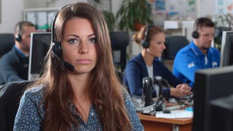 A busy office of a moving company focus on 3 people accepting customer calls